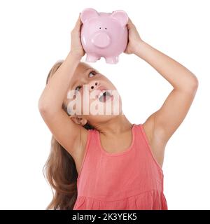 Garder un œil sur ses économies. Une adorable petite fille à la recherche d'argent dans sa banque de porc. Banque D'Images