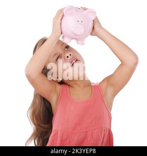 Garder un œil sur ses économies. Une adorable petite fille à la recherche d'argent dans sa banque de porc. Banque D'Images