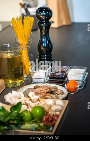 Axé sur la crevette parmi les ingrédients, lime, champignon, échalote, citronnelle, oignon de printemps, chili, tobiko, bergamote, fromage et spaghetti repas coo Banque D'Images