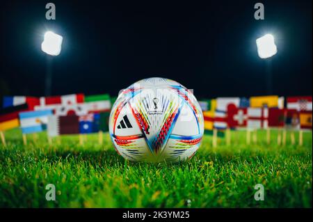 PARIS, FRANCE, 6 SEPTEMBRE 2022 : ballon officiel de football de la coupe du monde Adidas Al Rihla sur gazon vert. Les drapeaux des 32 nations participent au World C de la FIFA Banque D'Images