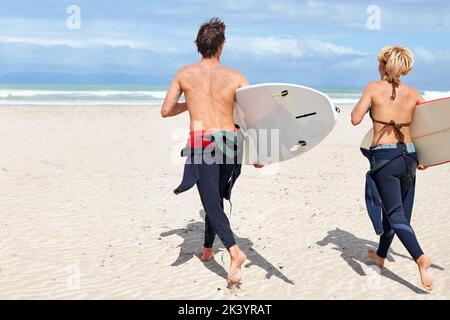 Le surf est au-delà de la dynamisant. Les jeunes surfeurs sont enthousiastes à l'idée de frapper les vagues. Banque D'Images