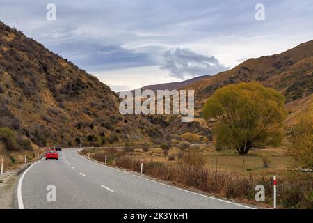 La route de la vallée de Cardrona, Otago, Nouvelle-Zélande, traversant un paysage d'automne entre Queenstown et Wanaka Banque D'Images