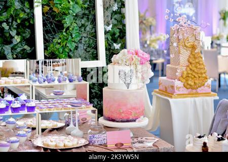 Barre de bonbons. Gâteau blanc-rose, avec fleurs roses, feuille d'or et messages d'amour Banque D'Images