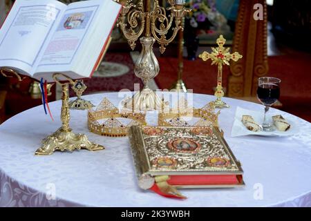 Deux couronnes pour une cérémonie de mariage orthodoxe , la bible et un verre de vin rouge Banque D'Images
