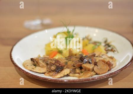 Faire sauter les champignons avec une garniture de pommes de terre et de poivrons. Banque D'Images