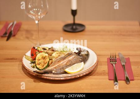 Truite frite aux champignons sautés et légumes grillés. Banque D'Images