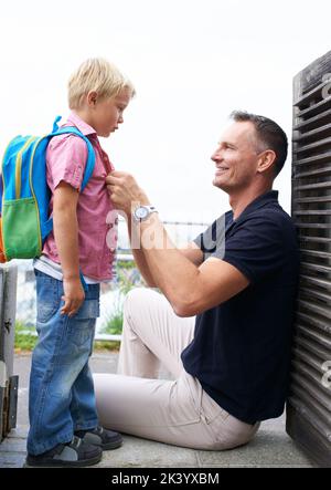 Se préparer pour sa première journée à l'école. Un père aidant son fils à se préparer pour l'école. Banque D'Images