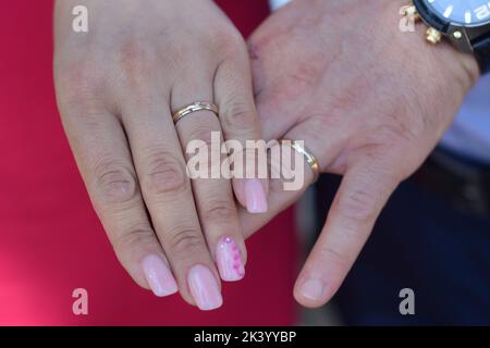 Couple marié. Main de femme et d'homme avec anneaux de mariage en vue. Banque D'Images