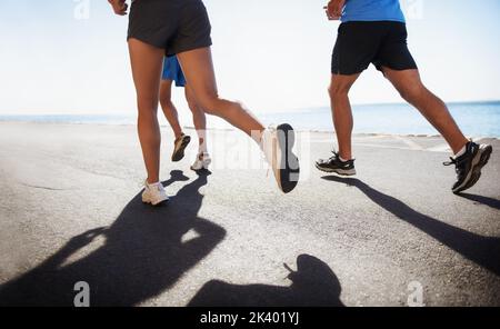 Courir est un mode de vie. Vue à angle bas d'un coureur à côté de l'océan. Banque D'Images