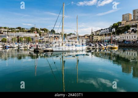 Les bateaux amarrés dans le port se reflètent dans l'eau calme du quai intérieur. Torquay, Devon, Angleterre, Royaume-Uni, Grande-Bretagne Banque D'Images