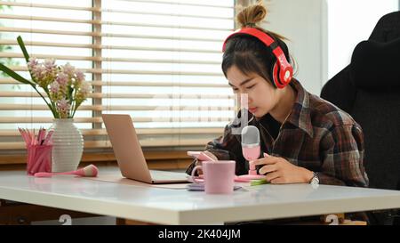 Microphone et ordinateur portable de jeune femme asiatique enregistrant un podcast Internet pour la chaîne de médias sociaux Banque D'Images