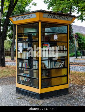 Ancienne boîte téléphonique jaune maintenant une minuscule bibliothèque de prêt, Lübars,Reinickendorf,Berlin Banque D'Images