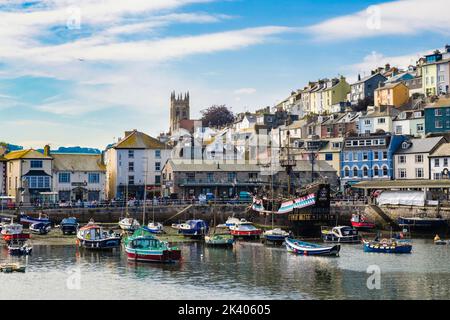 Maisons et boutiques sur le port intérieur avec de petits bateaux amarrés dans la pittoresque Brixham, Devon, Angleterre, Royaume-Uni, Grande-Bretagne Banque D'Images