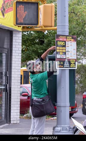 Un installateur de panneaux présente un panneau yiddish protestant contre les règles de l'État en matière d'éducation laïque. Sur Lee Ave. À Williamsburg, Brooklyn, New York City. Banque D'Images