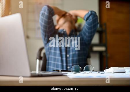 Stressé et malheureux homme d'affaires asiatique du millénaire ou employé de bureau de sexe masculin prend ses lunettes sur la table, souffrant de son anxiété, de sa dépression, Banque D'Images