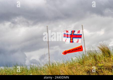 RNLI pas de drapeau des Inflatables volant à la plage. Banque D'Images