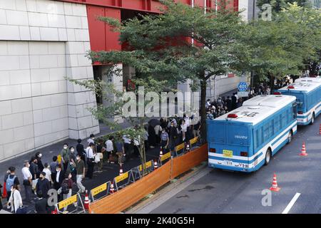 Les gens attendent dans la file pour prier et offrir des fleurs au stand de fleurs spécialement installé à l'extérieur de Nippon Budokan, où les funérailles d'État de l'ancien Premier ministre japonais Shinzo Abe se tient à 27 septembre 2022 à Tokyo, au Japon. Banque D'Images