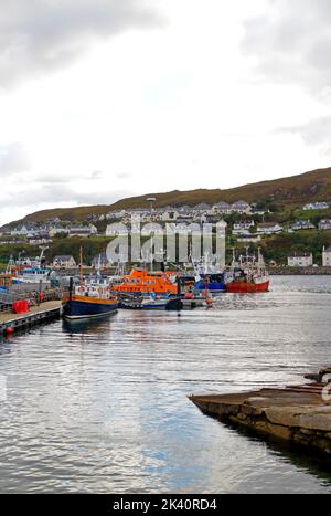 Vue sur les bateaux de pêche commerciaux et le RNLI Lifeboat amarré sur la côte ouest de l'Écosse dans le port et le port de Mallaig, Morar. Écosse, Royaume-Uni. Banque D'Images