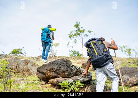 Vue arrière de suivi des randonneurs d'âge moyen escalade de la colline ou de la montagne - concept d'aventure, activités de loisirs et trekking. Banque D'Images
