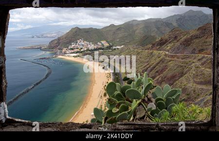 La plage artificielle de sable blanc, touristique de la Playa de Las Teresitas, vue du Mirador, encadrée par la fenêtre d'un bâtiment en ruines. Banque D'Images