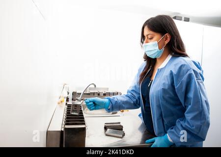 Une jeune scientifique féminine déshydratant des échantillons de tissus inclus en paraffine en laboratoire. Élimination de la paraffine à base de xylène. Banque D'Images