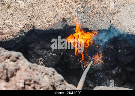 Un feu provenant de la chaleur volcanique, Parc national de Timanfaya, Lanzarote, îles Canaries, Espagne Banque D'Images