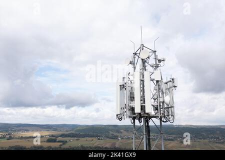 Tour cellulaire transportant des antennes de réseaux cellulaires émetteur GSM récepteur contre ciel nuageux et paysage, Dynów, septembre 2022. Banque D'Images