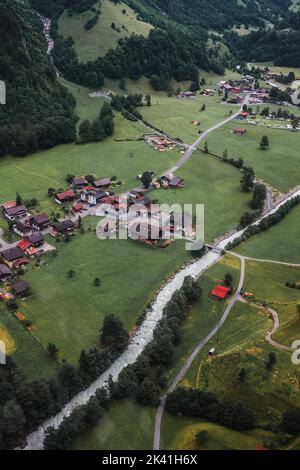 Lauterbrunnen, Suisse, Jungfrau. Alpes suisses. Petit village confortable dans les montagnes, rivière, maisons en bois, arbres, route d'en haut. Photographie aérienne. Banque D'Images