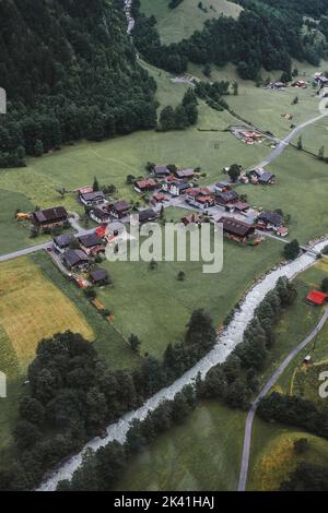 Lauterbrunnen, Suisse, Jungfrau. Alpes suisses. Petit village confortable dans les montagnes, rivière, maisons en bois, arbres, route d'en haut. Photographie aérienne. Banque D'Images