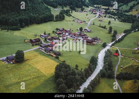 Lauterbrunnen, Suisse, Jungfrau. Alpes suisses. Petit village confortable dans les montagnes, rivière, maisons en bois, arbres, route d'en haut. Photographie aérienne. Banque D'Images