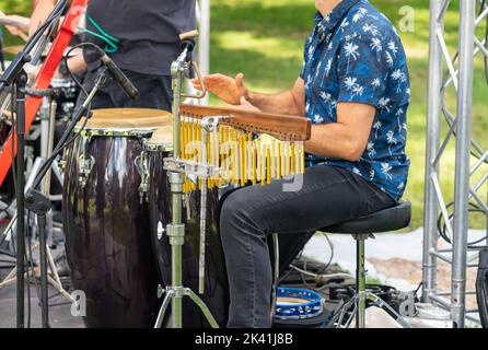 Un batteur dans un ensemble joue des tambours sur la scène d'un festival populaire de rue de près Banque D'Images