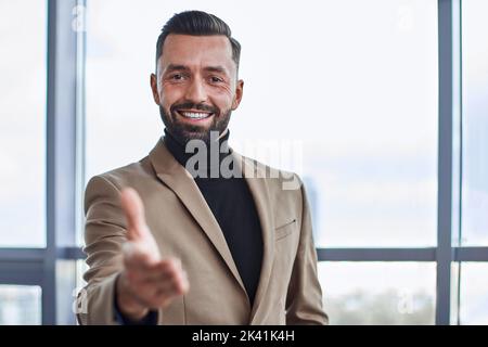 homme d'affaires souriant vous offrant sa poignée de main. gros plan. Banque D'Images