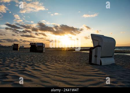 Plage de sable avec chaises de plage sur la côte de la mer Baltique au coucher du soleil, sur l'île de Poel, Allemagne Banque D'Images