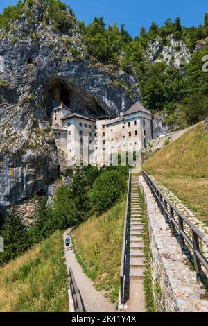 Le château de Predjama en Slovénie, le sentier de la colline et les escaliers menant au château de la grotte médiévale perché sur une falaise. Banque D'Images