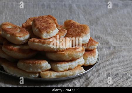 Cuisine ukrainienne traditionnelle - tartes avec pommes de terre. De nombreuses chaussons sur une plaque métallique Banque D'Images