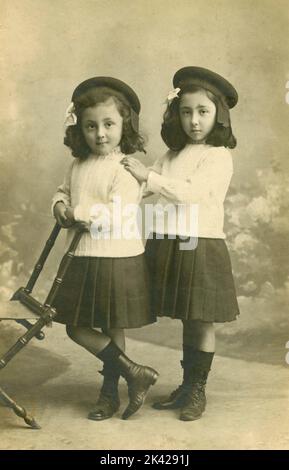 Studio portrait de deux filles jumelles vêtues de la même manière, Italie 1930s Banque D'Images