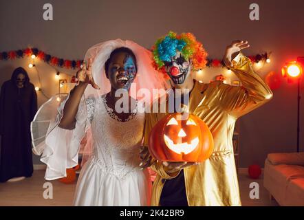 Deux heureux amis adultes vêtus de costumes d'Halloween de Dead Bride et Crazy Clown Banque D'Images