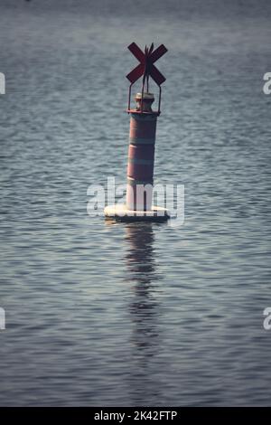 Bouée sur un lac au coucher du soleil Banque D'Images