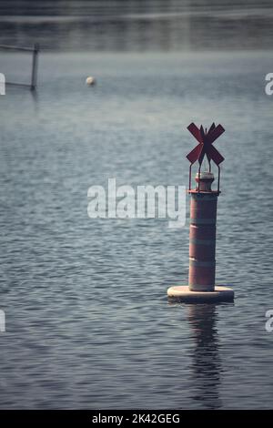 Bouée sur un lac au coucher du soleil Banque D'Images