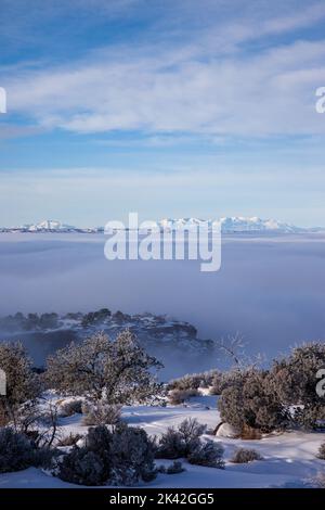 Une mer de brouillard remplit le bassin de la rivière verte, les sommets des falaises d'Orange et des montagnes Henry enneigées derrière. Vue depuis le point de vue de la tour Candlestick i Banque D'Images