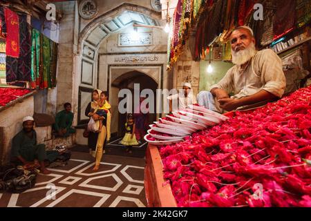 Delhi, Inde : Un vendeur se trouve dans un stand aux pétales de rose à l'entrée de Nizamuddin Dargah. Les bazars autour offrent toutes sortes d'attars (parfums) et Banque D'Images