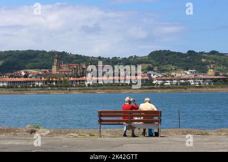 Un couple âgé regarde Hondarribia (Espagne) de l'autre côté de la rivière Bidasoa depuis Hendaye, pays basque français, France Banque D'Images