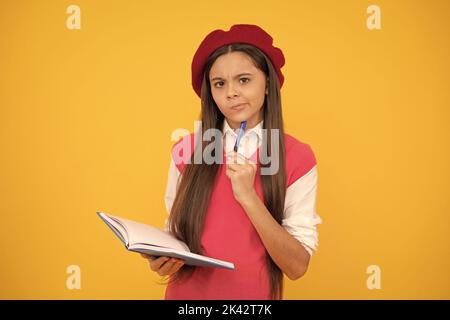 penser jeune fille d'école en béret français faire des notes dans le bloc-notes ou le bloc-notes de planificateur, septembre Banque D'Images