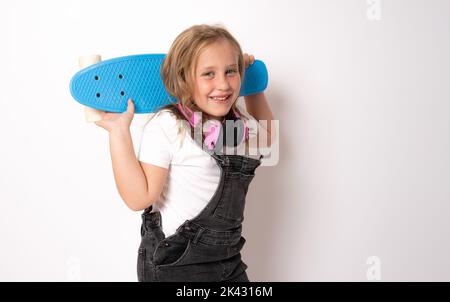 Belle petite blonde enfant fille de 7 ans en denim vêtements posant isolé sur fond blanc enfants portrait. Concept de style de vie d'enfance. Banque D'Images