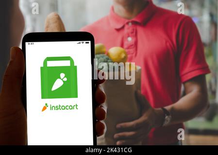 Dans cette illustration, le logo de l'application Quick Food and Grocery Delivery Instacart est affiché sur un écran de smartphone et sur un ordinateur portable. Banque D'Images