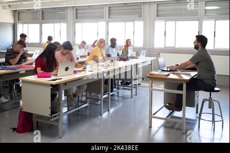 Classe secondaire avec un enseignant de sexe masculin et un groupe d'élèves multiethniques Banque D'Images