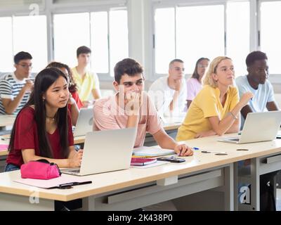 Groupe d'adolescents multiethniques écoutant la leçon en classe Banque D'Images
