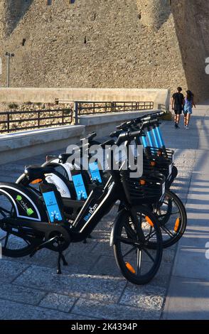 Termoli, Molise, Italie -08-29-2022- le vélo électrique partage une stationl en face du château souabe avec un jeune couple en arrière-plan Banque D'Images