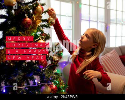 Composition du texte de noël sur une fille caucasienne décorant l'arbre de noël Banque D'Images