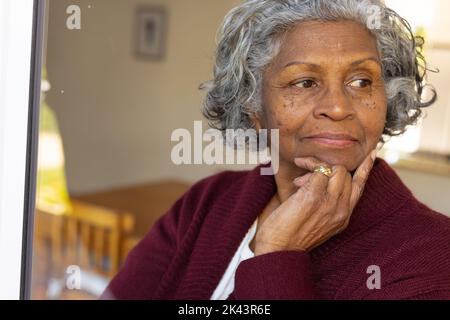 Des femmes africaines américaines séniors attentionnés qui regardent la fenêtre ensoleillée Banque D'Images